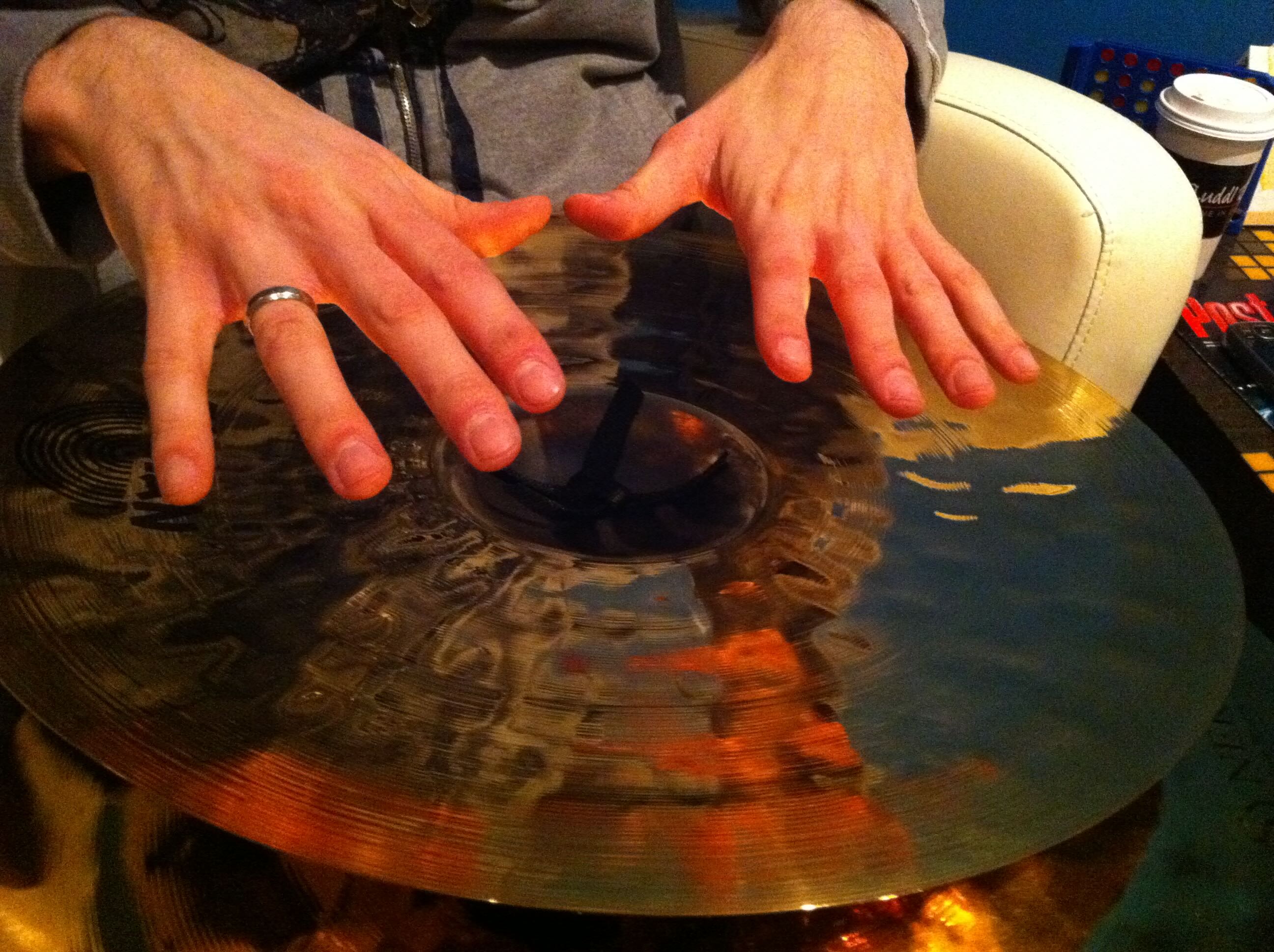 A close-up of a performer’s hands demonstrating technique on a Sabian cymbal